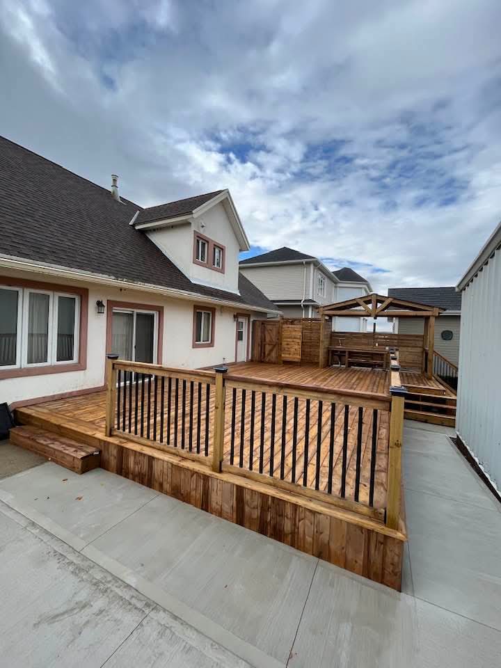 Finished cedar deck with black picket railings wrapping the home