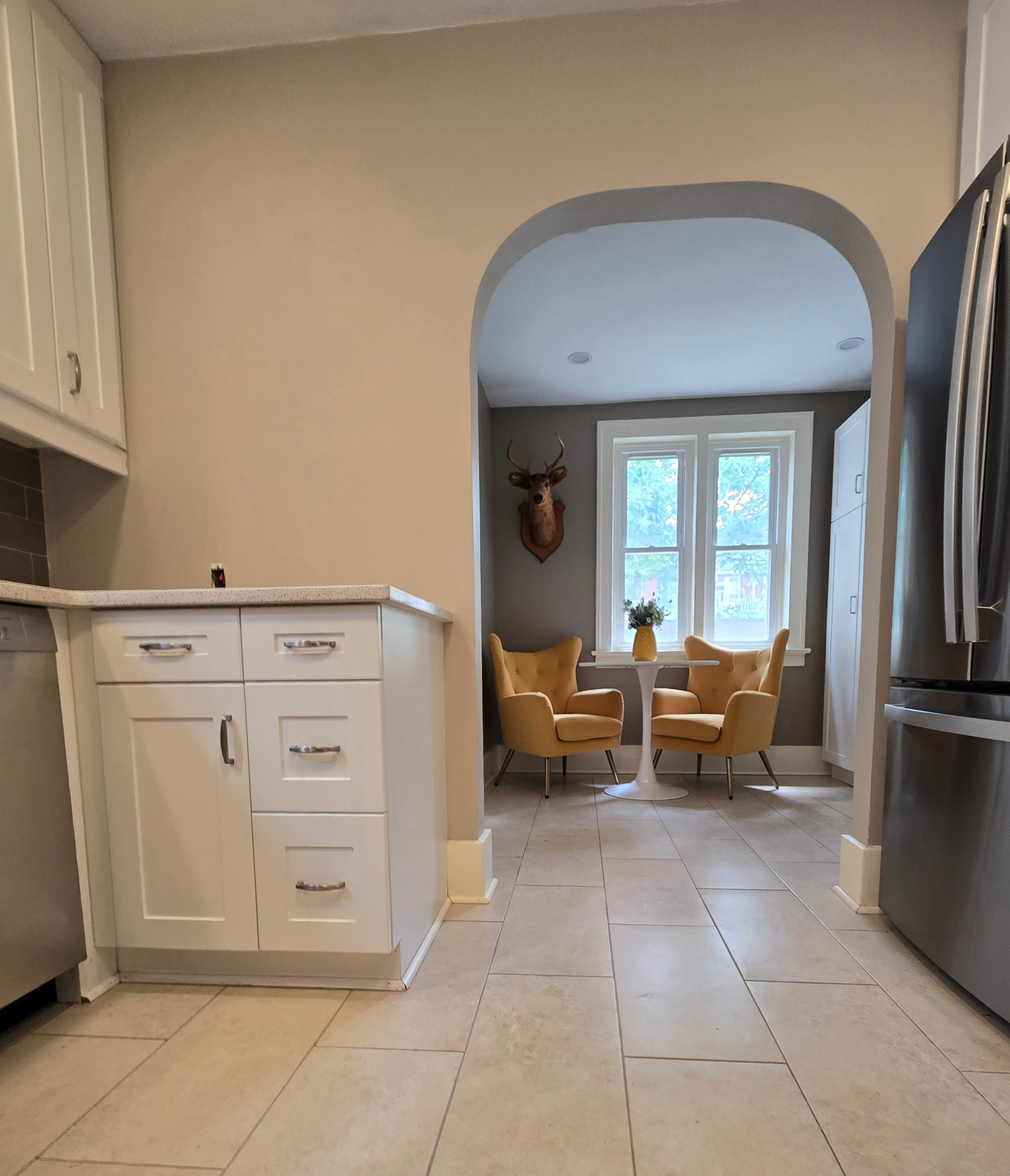 Kitchen before the stone feature wall, showing a plain painted wall beside the arched breakfast nook opening