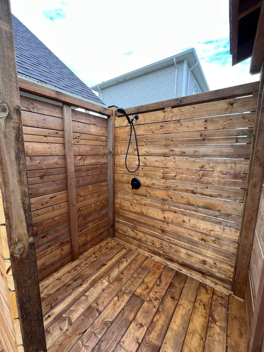 Cedar slat outdoor shower enclosure built into the deck