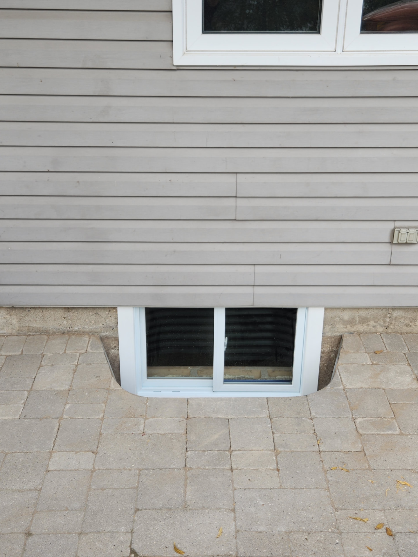 Completed egress window with finished well, trim and landscaping restored