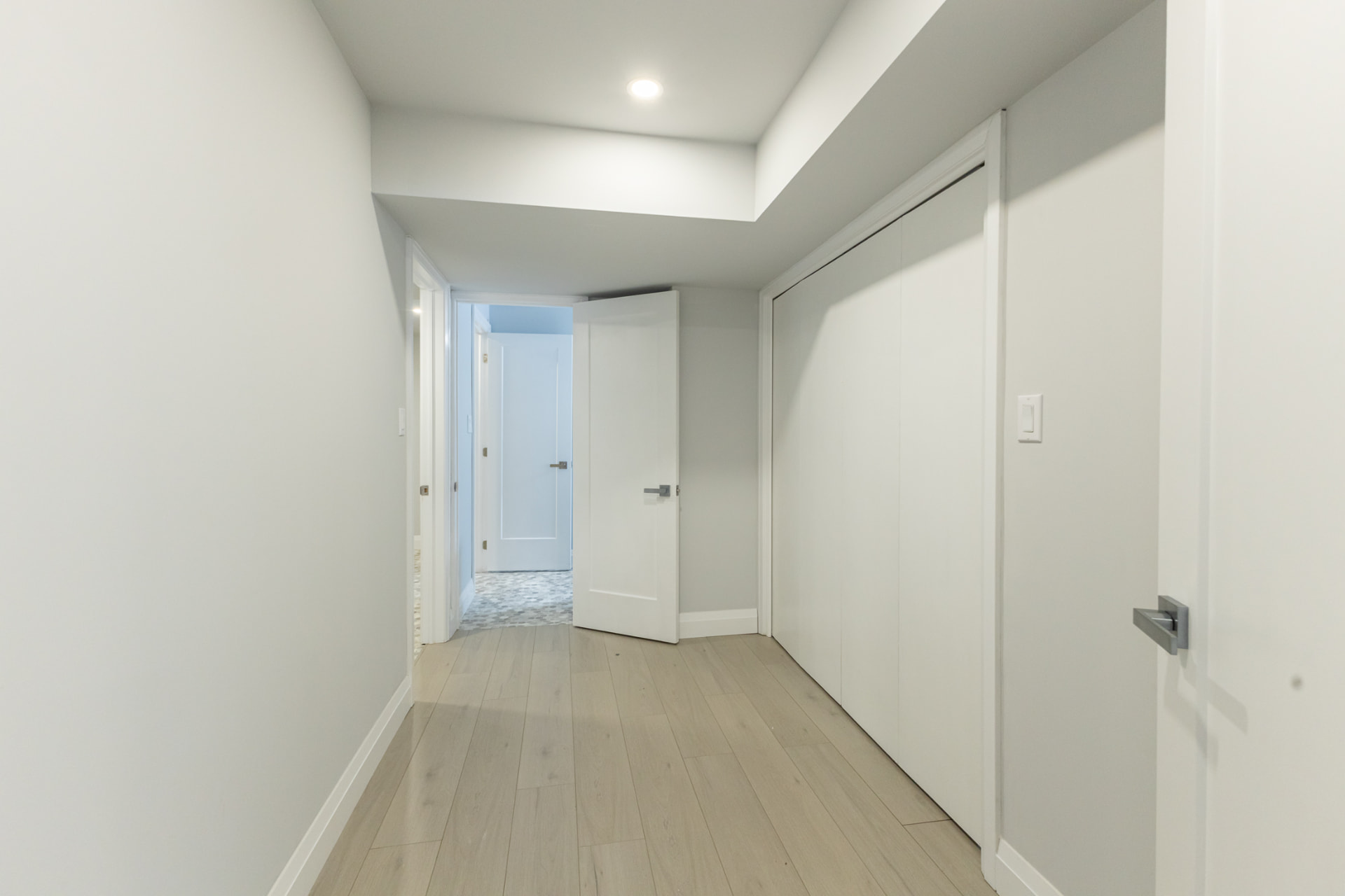Finished basement hallway with closet doors and new trim