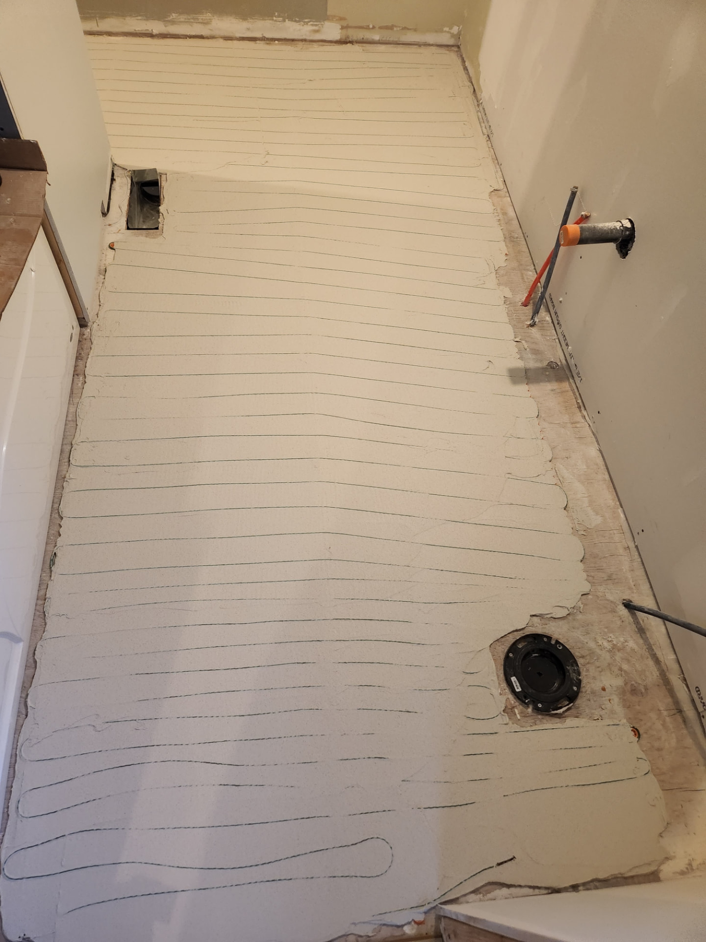 Self-levelling compound poured over the in-floor heating system